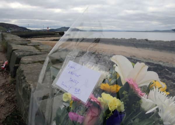 Flowers left at the scene at Buncrana Pier in Co Donegal where five people were killed after their car slipped into the water.