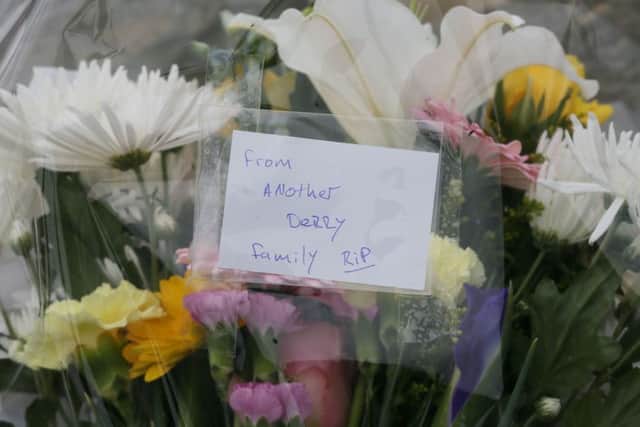 Flowers left at the scene at Buncrana Pier in Co Donegal after five people, including at least two children, have been killed and a baby girl is in hospital after a car they were in slipped from the pier