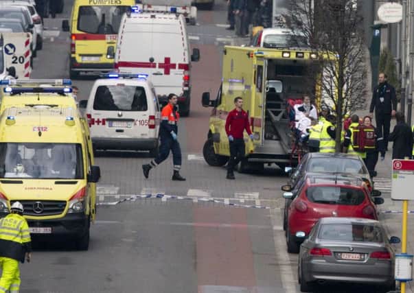 A woman is evacuated in an ambulance by emergency services after a explosion in a main metro station in Brussels on Tuesday, March 22, 2016. Explosions rocked the Brussels airport and the subway system Tuesday, killing at least 13 people and injuring many others just days after the main suspect in the November Paris attacks was arrested in the city, police said