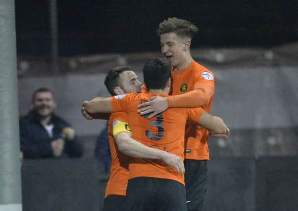 Carrick's Aaron Harmon (left) celebrates with Aaron Traynor and Adam Salley after making it 3-0 at Taylor's Avenue.