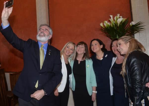 Sinn Fein leader Gerry Adams takes a selfie with party members  at the Easter Rising event in Stormont