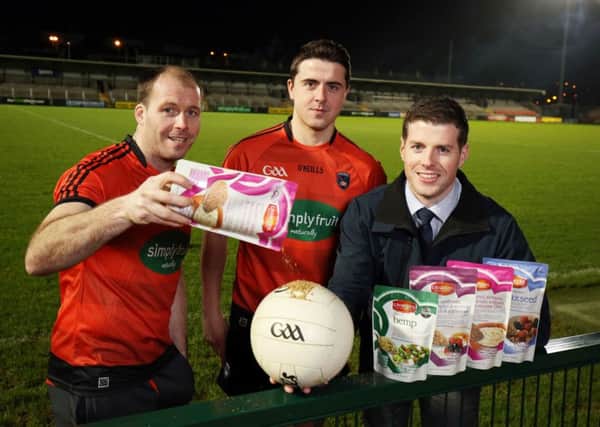 Armagh GAA players Ciaran McKeever and Stefan Campbell with Patrick Woods Director Linwoods