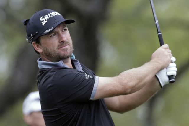 Graeme McDowell watches his tee shot on the first hole