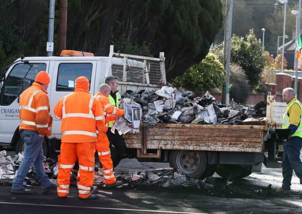A council van assists in the clear-up operation after a vehicle had been set alight in Lurgan