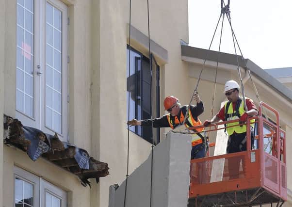 Workers with BELFOR Restoration Company remove part of a fourth floor balcony that fall onto the balcony below at the Library Gardens apartment complex in Berkeley, Calif. on Tuesday, June 16, 2015