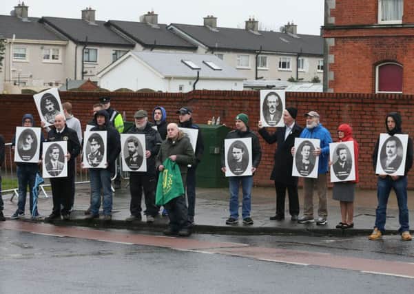Protesters hold placards outside Glasnevin cemetery in Dublin, as a list of all those who died in the 1916 Easter Rising, including rebellion leaders and British soldiers, has been unveiled in Glasnevin cemetery in Dublin