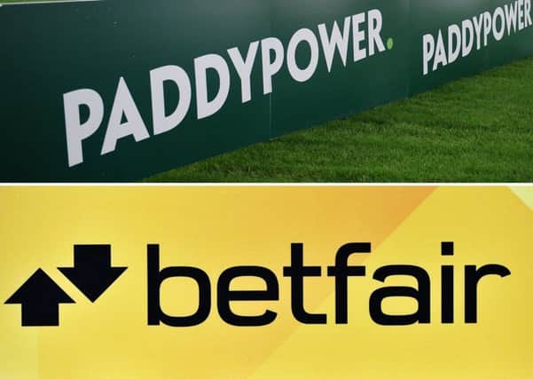 File photos of a general view of Paddy Power branding and signage and a Betfair logo, as about 650 jobs are to be cut at the newly formed bookmaking giant Paddy Power Betfair
