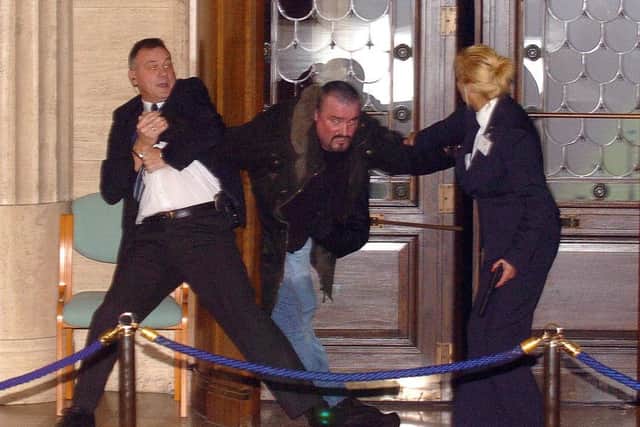 Renegade Loyalist Michael Stone is tackled by security officers as he enters Stormont