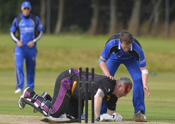 Mandatory Credit:  Rowland White/PressEye
Cricket: Ulster Bank Challenge Cup Final
Teams: CIYMS (blue) v Instonians (black)
Venue: The Green, Comber
Date: 1st August  2015
Caption: Neil Russell of Instonians is floored after taking a ball on the head from Johnny Thompson, CIYMS