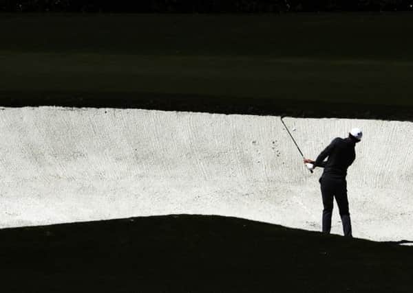 Rory McIlroy hits from a bunker on the fourth hole