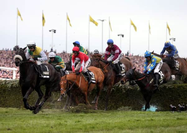 Rule The World ridden by jockey David Mullins (no.29) clear a fence on the way to winning the Crabbie's Grand National Chase