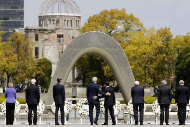 U.S. Secretary of State John Kerry, centre left, puts his arm around Japan's Foreign Minister Fumio Kishida, center right, after they and fellow G7 foreign ministers laid wreaths at the cenotaph at Hiroshima Peace Memorial Park in Hiroshima (in front of the Atomic bomb dome)on Monday April 11, 2016. Also pictured are, from left to right, E.U. High Representative for Foreign Affairs Federica Mogherini, Canada's Foreign Minister Stephane Dion, Britain's Foreign Minister Philip Hammond, Germany's Foreign Minister Frank-Walter Steinmeier, Italy's Foreign Minister Paolo Gentiloni and France's Foreign Minister Jean-Marc Ayrault.  (Jonathan Ernst/Pool Photo via AP)