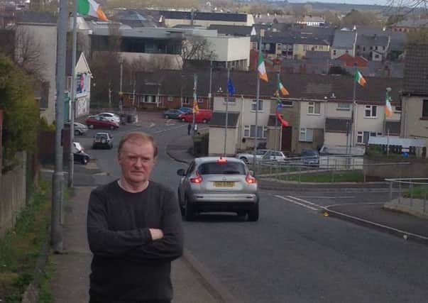 Russell Watton PUP Councillor at flags outside St Johns Primary School Coleraine