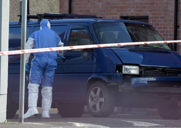 A forensics officer at the scene of the van bomb that killed prison officer Adrian Ismay last month