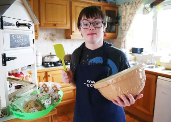 Ryan Bogues, 21, with his 'Ryan's Cookie Box' at his home in Ballynahinch in Co Down