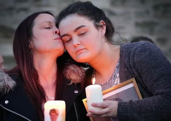 Widow Joanne McGibbon (centre) with her daughter at a vigil in the grounds of Holy Cross Church, Ardoyne,