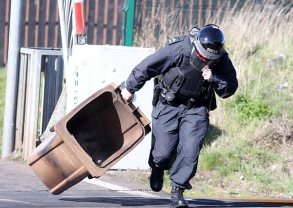 A PSNI officer removes the bin from the railway in Lurgan after trouble flared in the Lake Street area on March 28. 

Picture by Jonathan Porter/PressEye
