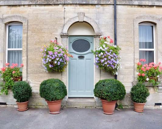 Hanging baskets on the exterior of a Victorian cottage