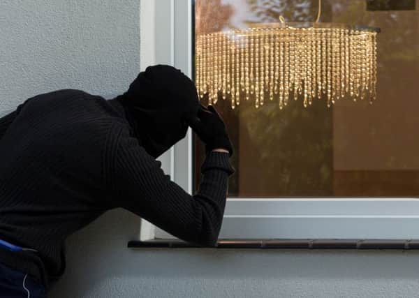 A Generic Photo of a burglar attempting to break into a property through a window