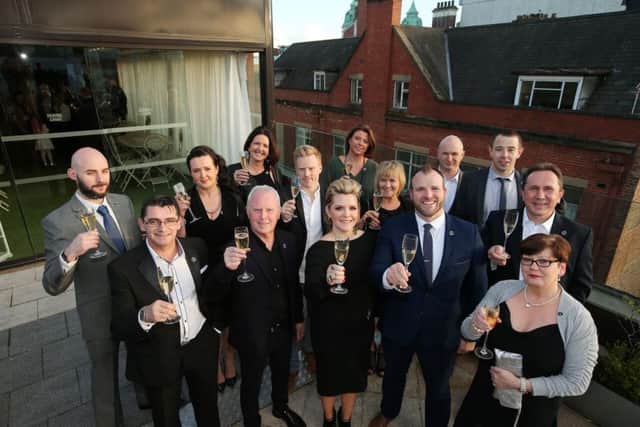 The owner of the Merchant Hotel, Bill Wolsey, front row, second left, pictured with his wife Petra, centre, and staff who have been with the hotel since it opened in Belfasts Cathedral Quarter 10 years ago