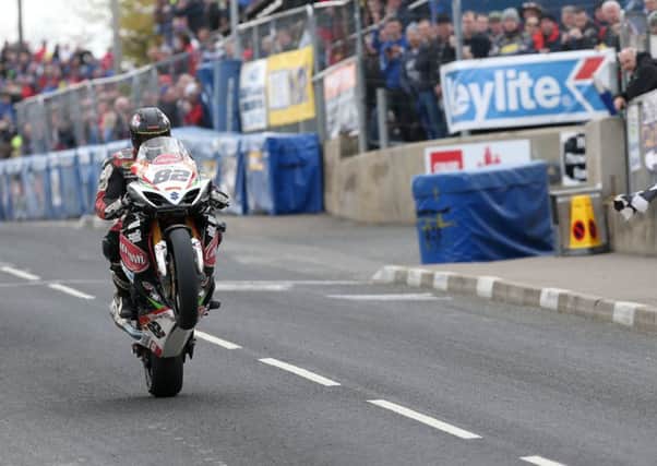 Derek Sheils takes the chequered flag to win the Cookstown 100 feature race on the Burrows Engineering Suzuki.