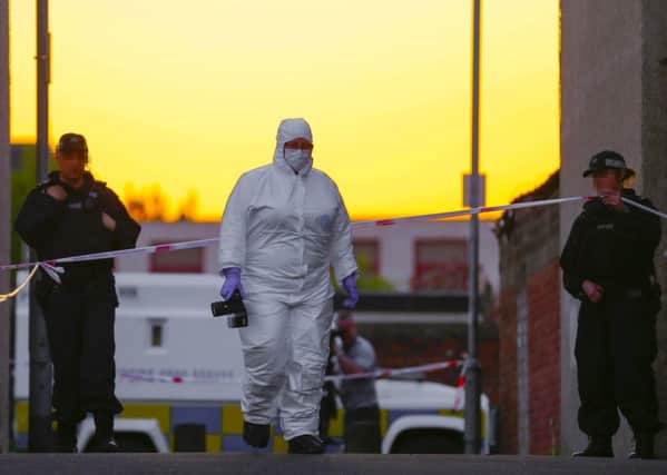 Police and forensics officers at the scene where a 17-year-old has been shot