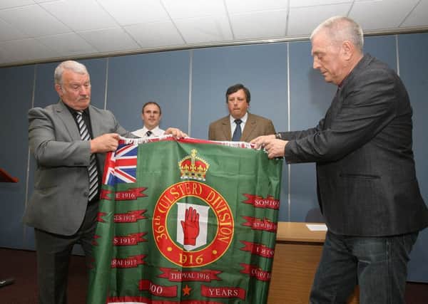 The new flag was unveiled in May by the Loyalist Communities' Council (LCC). In the foreground (left), is ex-Red Hand Commando internee Jim Wilson, with UDA leader Jackie McDonald on the right