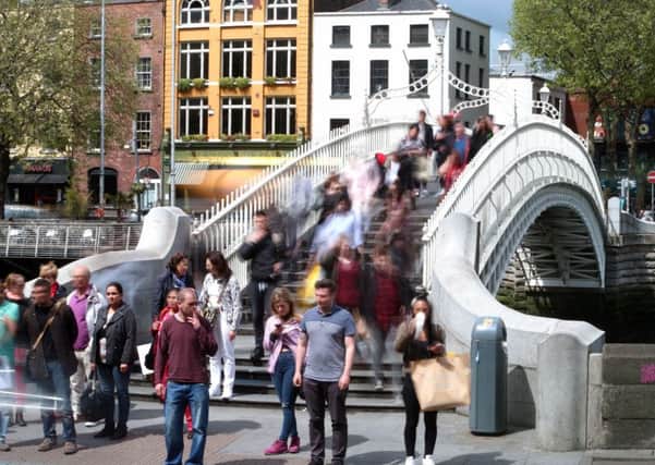 People on the Ha'penny Bridge in Dublin celebrating its 200th birthday