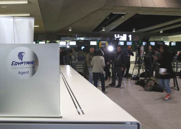Reporters gather in front of the EgyptAir counter at Charles de Gaulle Airport outside of Paris, Thursday, May 19, 2016. An EgyptAir flight from Paris to Cairo carrying 66 people disappeared from radar early Thursday morning, the airline said
