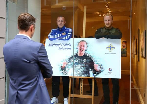 Northern Ireland players Luke McCullough and Liam Boyce pictured with manager Michael O'Neill's poster at James Wray Gallery, Belfast