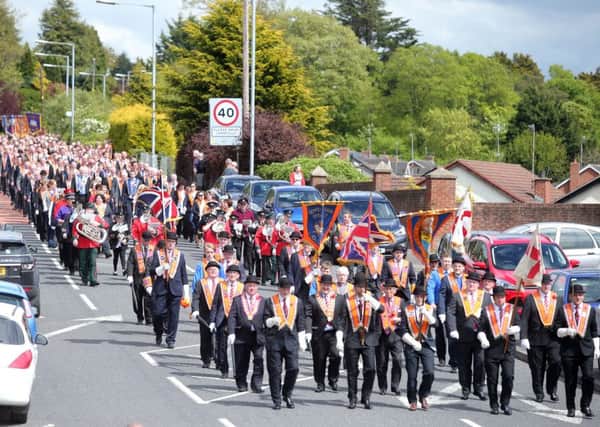 Orangemen march through Dromore in Co Down, laying a wreath at the war memorial before heading to the church service in the town's cathedral