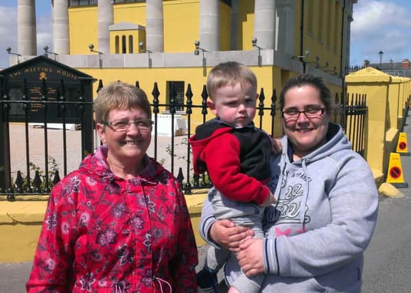 Roisin Lennon, left, and Grainne Lennon with her son Stephen Traynor, 2, from Portaferry, outside the Presbyterian Church while Prince Charles was attending a service inside