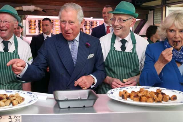 The Prince of Wales and the Duchess of Cornwall sample award-winning sausages made by brothers Diarmuid (left) and Ernan McGettigan at McGettigan's butcher's shop in Donegal Town
