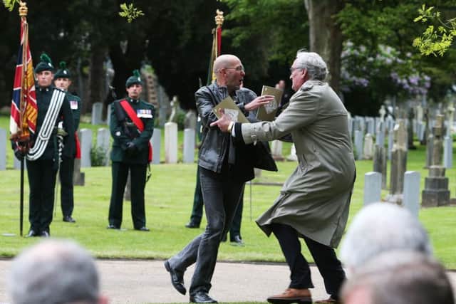 Canadian Ambassador to Ireland Kevin Vickers wrestles with a protester (left) during a State ceremony to remember the British soldiers who died during the Easter Rising at Grangegorman Military Cemetery, Dublin.  Photo: Brian Lawless/PA Wire