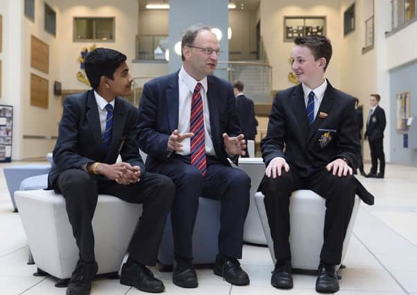 Peter Weir with Bangor Grammar School pupils Rohith Ajayakumar (left) and Josh Hardy