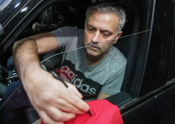 Football manager Jose Mourinho signs a Manchester United shirt outside his house in central London.  Photo: Daniel Leal-Olivas/PA Wire