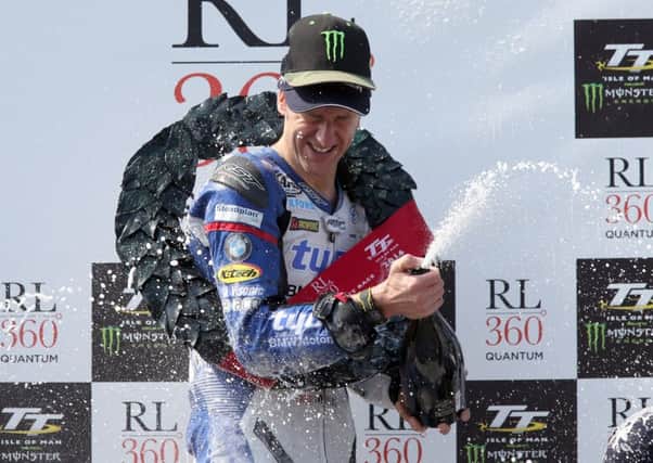 Ian Hutchinson celebrates his victory on the Tyco BMW in the Superstock race at the Isle of Man TT.