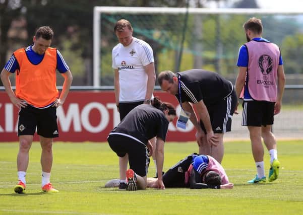 Northern Ireland's Kyle Lafferty lies injured during a training session at the Parc de Montchervet, Saint-Georges-de-Reneins