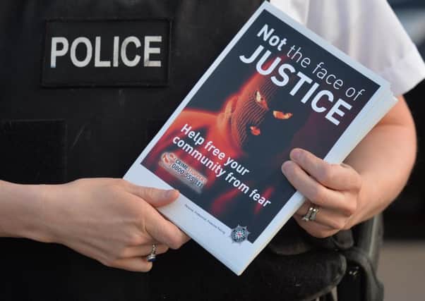 Last month PSNI officers handed out leaflets in west Belfast as a protest was held against paramilitary attacks.
 Picture: Colm Lenaghan/Pacemaker