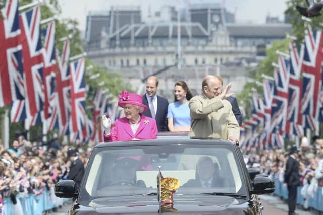 Queen Elizabeth II and the Duke of Edinburgh with the Duke and Duchess of Cambridge and Prince Harry make their way down The Mall on Sunday.