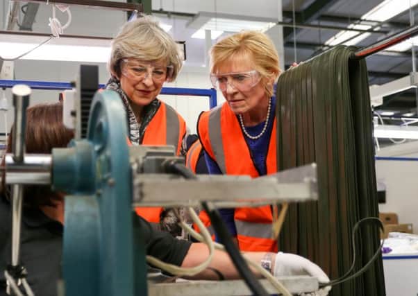 Home Secretary Theresa May MP (left) during a visit to Denroy Plastics Ltd with Lady Sylvia Hermon MP