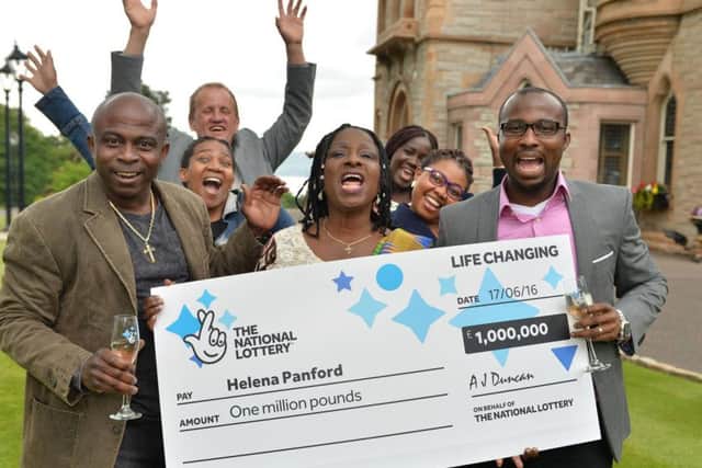 Helena Panford (59), originally from Ghana, pictured with her family and friends, won a staggering one million pounds after her bus broke down on the way to work