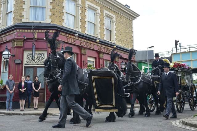 Undated BBC handout photo of the Carters showing their respects as Peggy's funeral procession pulls into Albert Square as EastEnders bosses have promised viewers "an emotional day"