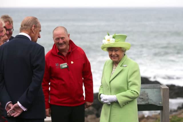 Queen Elizabeth II and the her husband, the Duke of Edinburgh, speaks to Neville McConachie during a visit to the Giant's Causeway on the Co Antrim coast during the second day of her visit to Northern Ireland to mark her 90th birthday