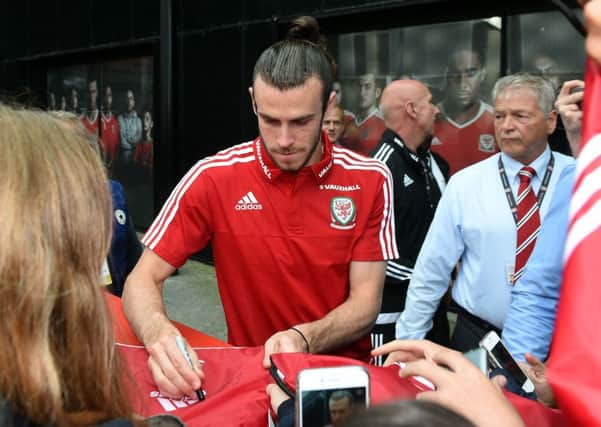 Wales' Gareth Bale signs autographs for fans after a press conference
