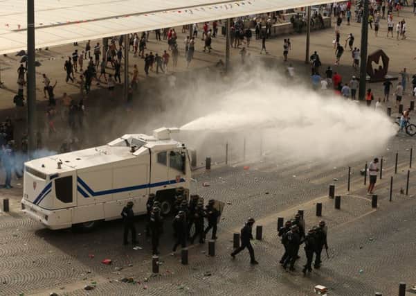 Police fire water cannons to control the fighting after football fans clashed ahead of the England vs Russia France Euro 2016 match in Marseille on June 11