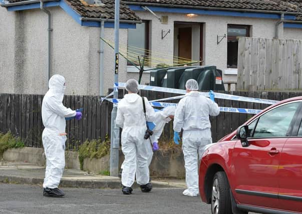 Forensic PSNI officers arrive at the scene of the sword attack in Belvoirin July last year