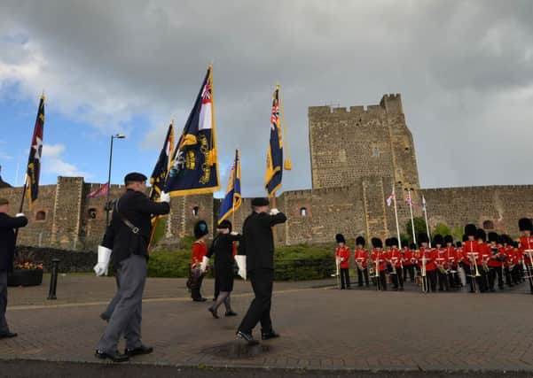 The Royal Irish Regiment Colour party makes its way past Carrickfergus Castle