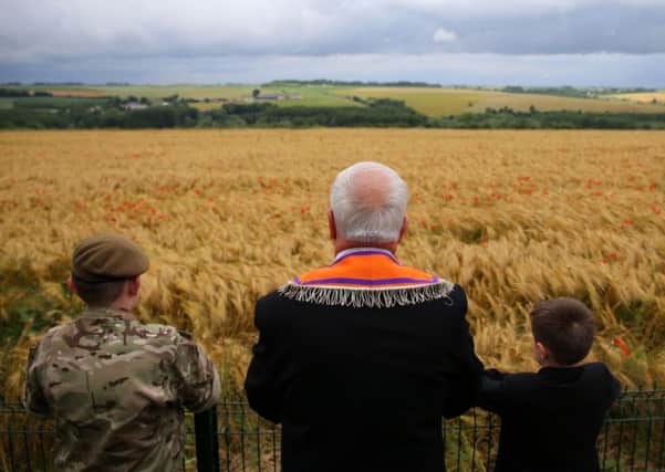 Former RUC officer Cecil Haire from Co Fermanagh and his grand children Aaron (left) and Calib (right) look out at a poppy field near the Ulster Memorial Tower at Thiepval, France, ahead of a ceremony to mark the Centenary of the Battle of the Somme.