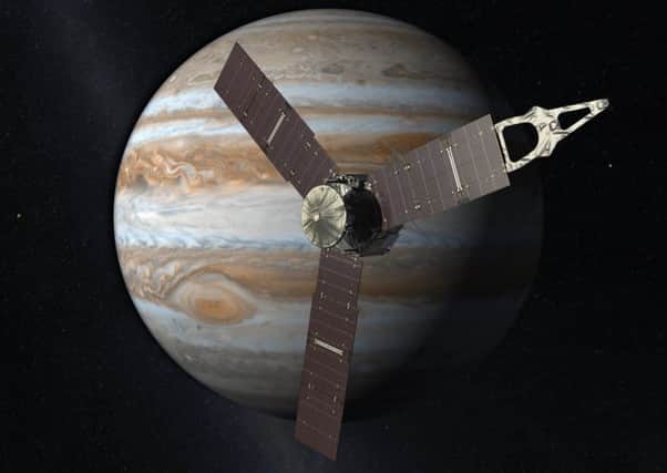 This artist's rendering provided by NASA and JPL-Caltech shows the Juno spacecraft above the planet Jupiter